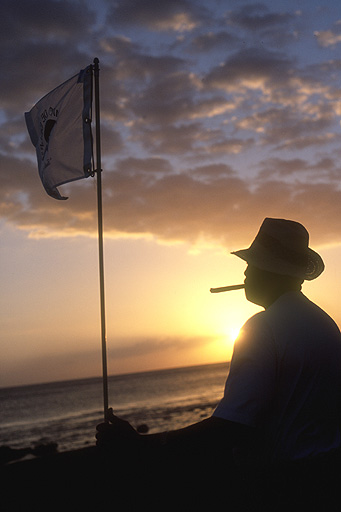 A golfer enjoys a Dominican cigar at sunset