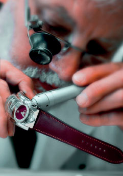 A watchmaker inspects a timepiece