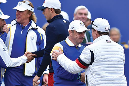 McGinley shakes hands with Tom Watson following the conclusion of the event