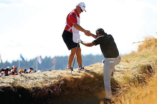Jason Day requiring the assistance of his caddie to make his escape from a bunker