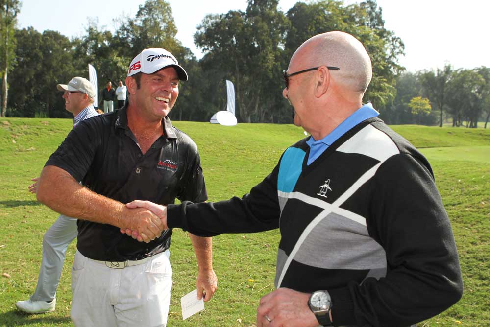The new champion receives a handshake from Ageas' CEO Stuart Fraser