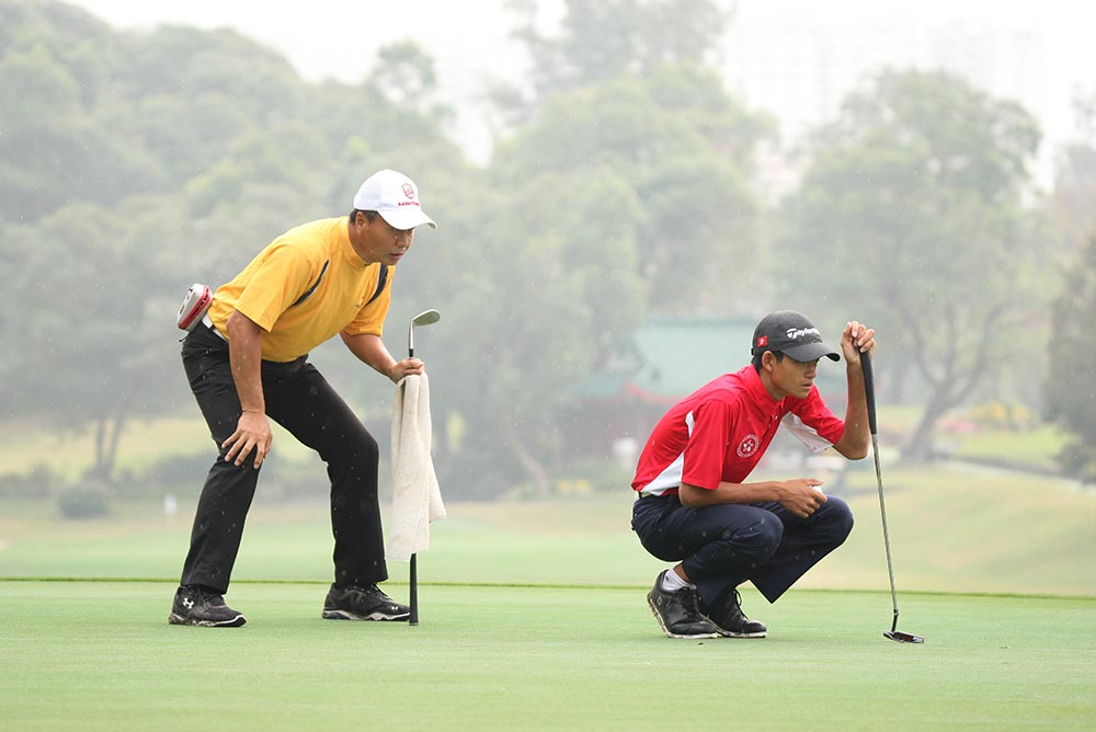 Taichi Kho lines up a putt as Victor reads with care