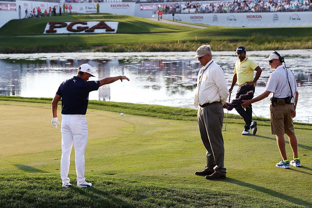 Rickie Fowler gets a ruling from PGA rules official during The Honda Classic
