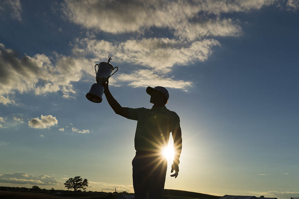 Brooks Koepka holds the trophy at Erin Hills