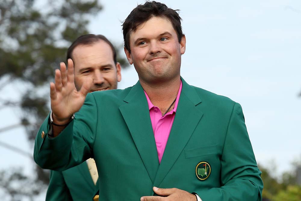 Patrick Reed is presented with the green jacket by Sergio Garcia